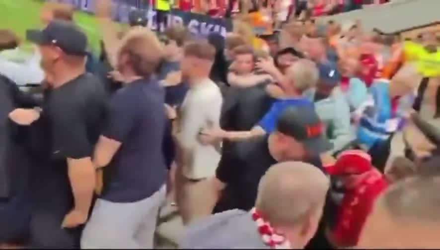 Liverpool fans celebrates excitedly after their team scores a goal against Bournemouth