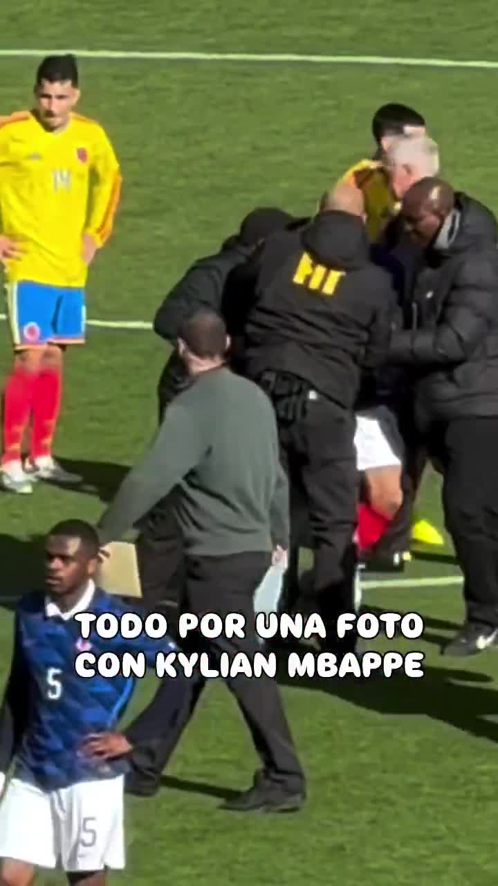 Kylian Mbappé attempts to intervene as security approaches a pitch invader and takes a photo with him