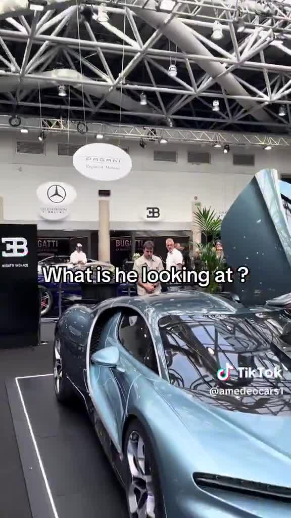 Fernando Alonso inspecting a Bugatti Tourbillon at a high-end car show