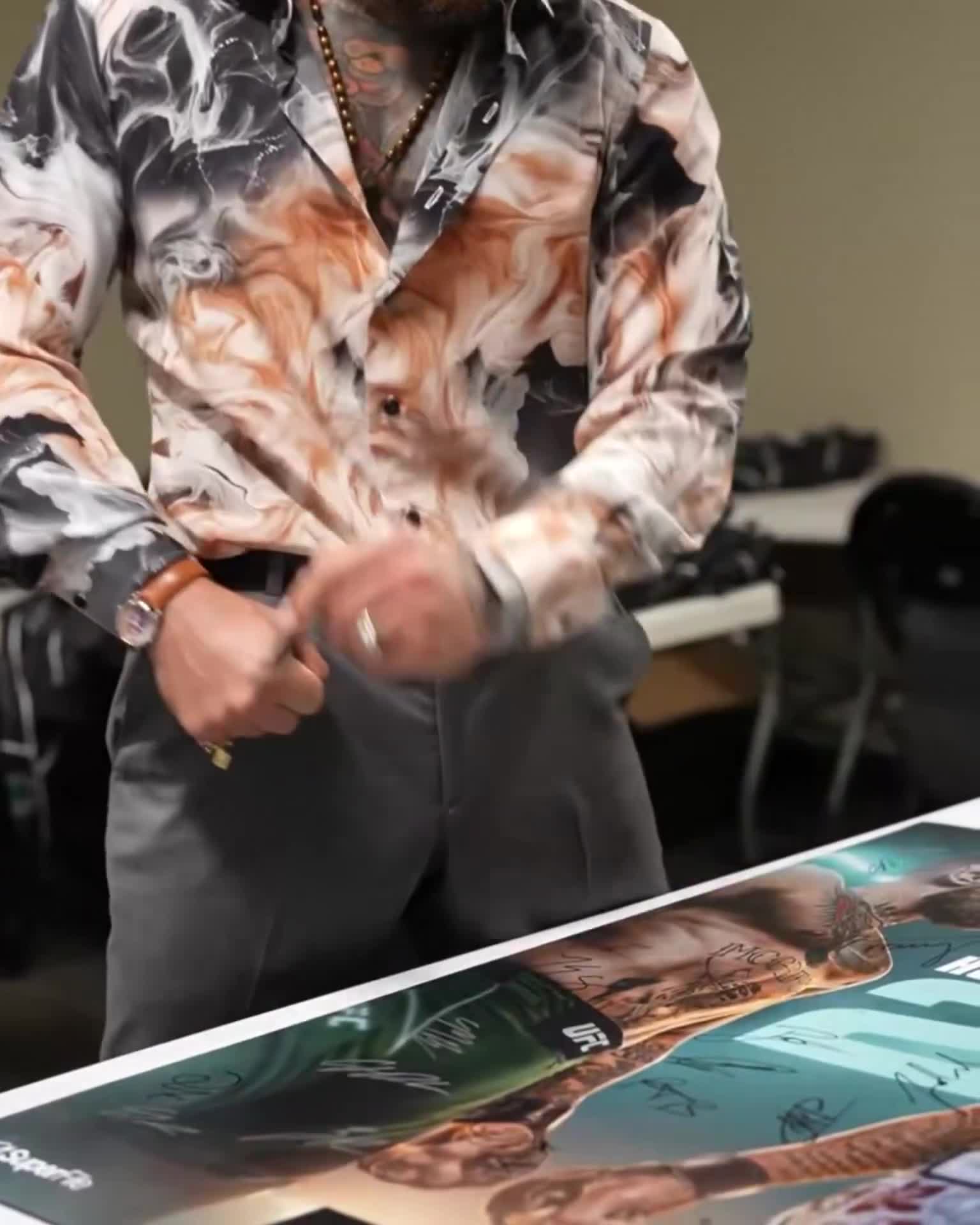 Conor McGregor leaving his infamous signature on the Max Holloway fight posters